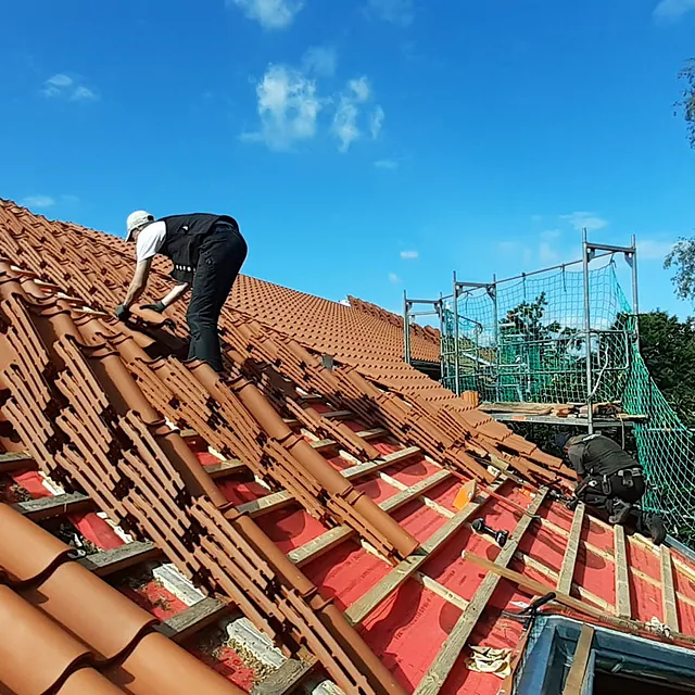 Dachdecker bei der Neueindeckung eines Ziegeldachs – Dacharbeiten von Burmester Dachdeckermeister in Ratzeburg