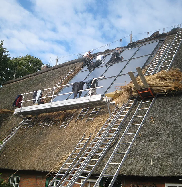 Arbeiten an einem Reetdach mit Gerüst – Reetdachdecker Burmester aus Ratzeburg