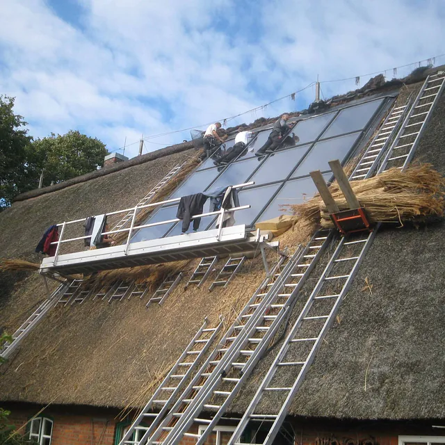 Arbeiten am Reetdach mit integriertem Dachfenster – Reetdachsanierung durch Burmester Dachdeckermeister Ratzeburg