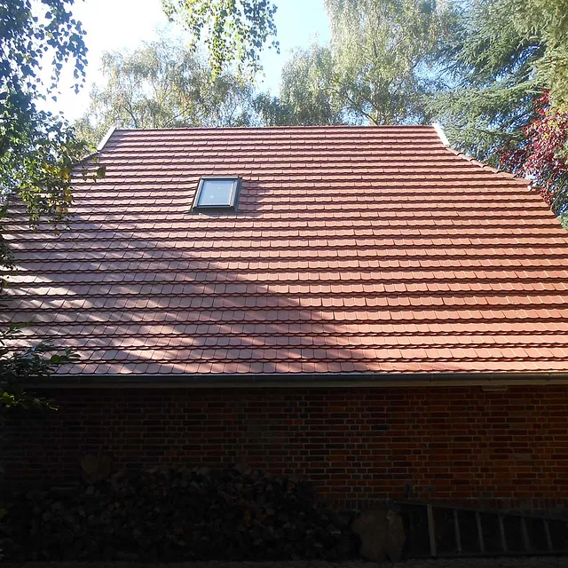 Steildach mit roten Dachziegeln und Schornsteinverkleidung – Dacharbeiten von Burmester Dachdeckermeister